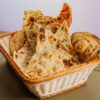 A variety of traditional Indian breads like naan and roti in a wicker basket, perfect for a delicious meal.